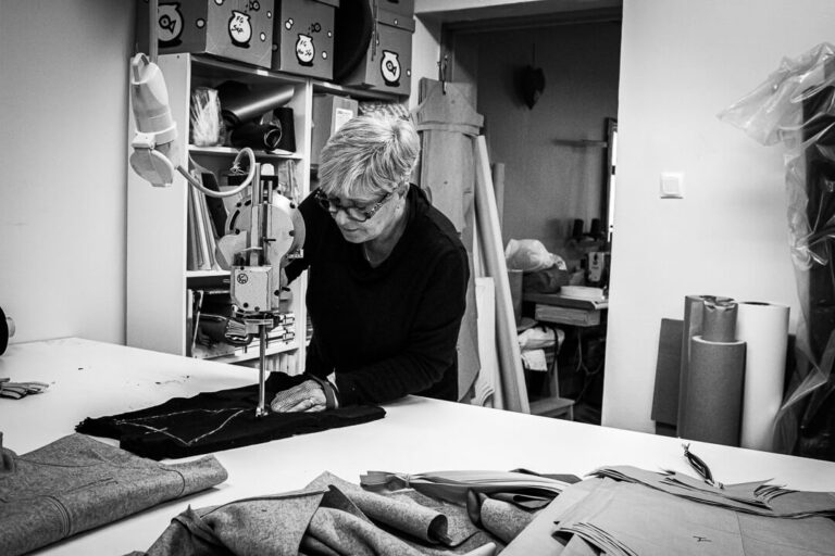 Couturière découpant un panneau de laine avec une scie électrique spécialisée à La Bénisson-Dieu.