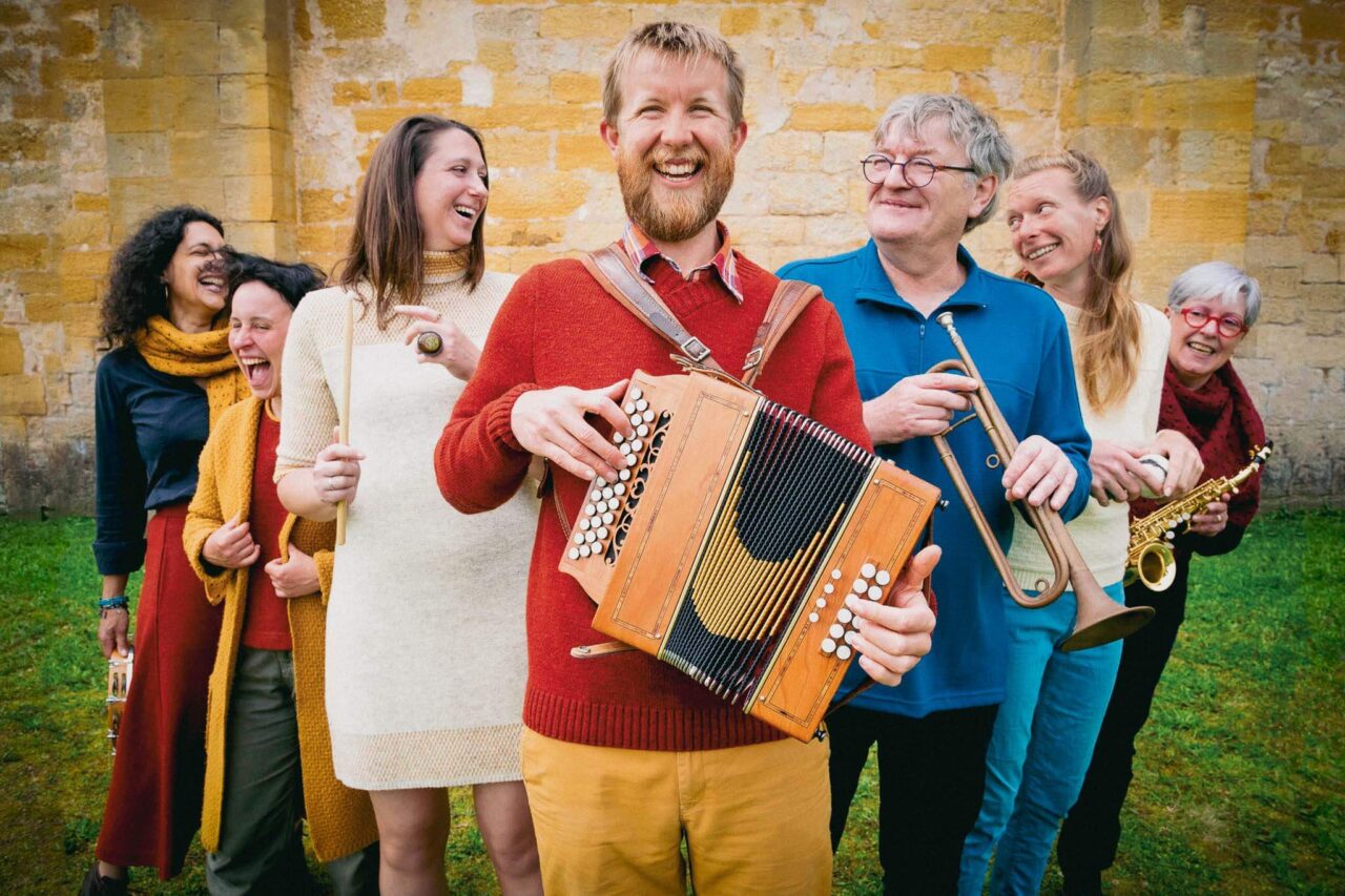 Sept personnes souriantes portant des vêtements en laine Ardelaine, fabriqués en France.