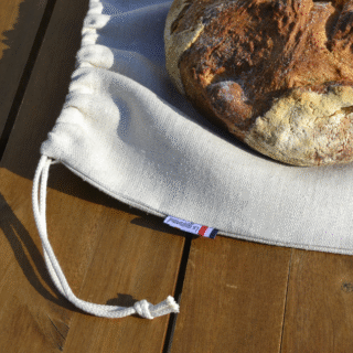 Sac à pain le Gourmand, posé sur une table avec un gros pain au levain