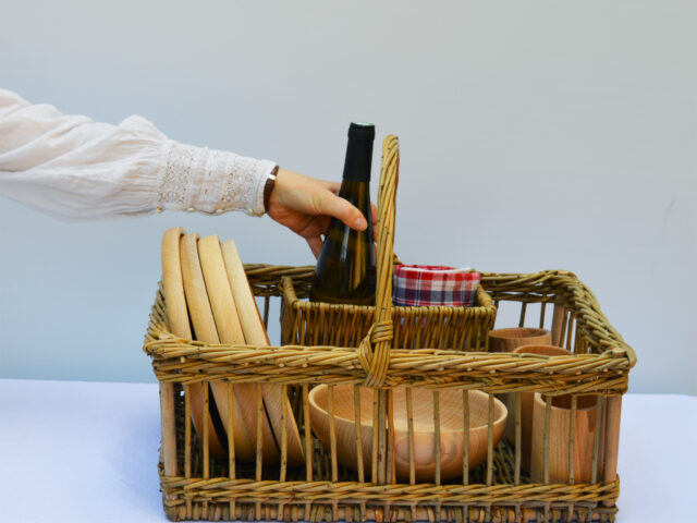Panier en osier avec vaisselle en bois de hêtre tournée en Alsace, avec un torchon en kelsch (tissu traditionnel alsacien).