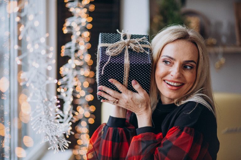 mature-woman-with-christmas-gift-by-bthe-window