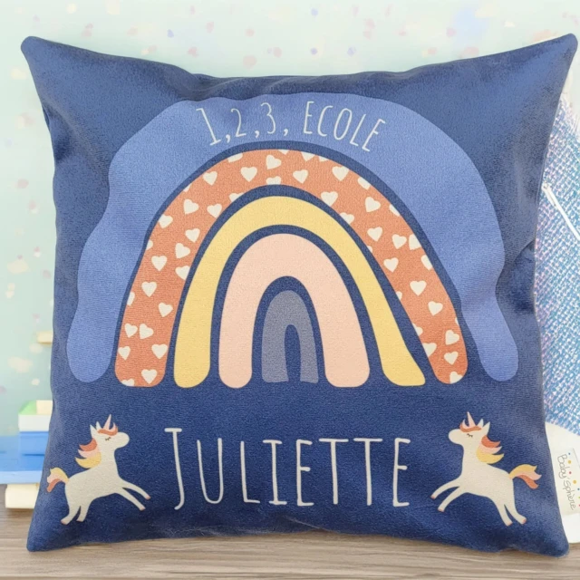 L’Atelier BABY’SPHERE - Coussin prénom arc en ciel fond bleu