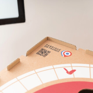 Gros plan sur le logo "Fabriqué en France" et un QR code imprimés sur le carton d'une cabane.