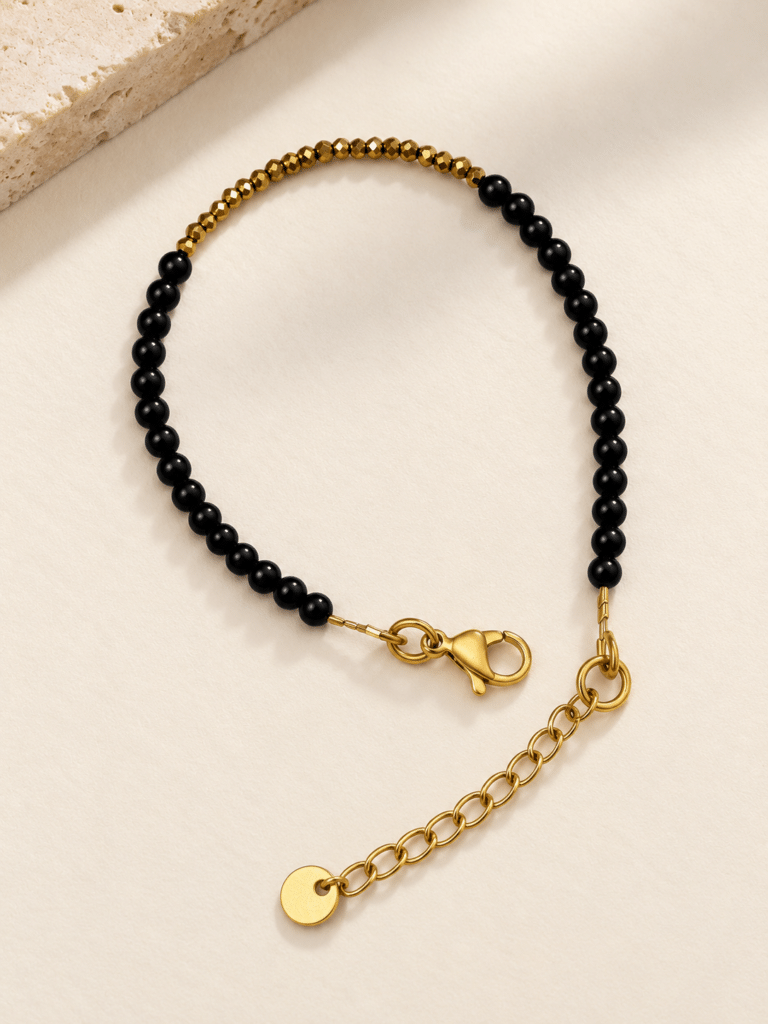 Bracelet Ava noir et or sur fond creme 768x1024 1 Maison Mallow - Bracelet Ava - onyx noir et hématite dorée